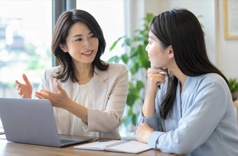 パソコンを見ながら話をする二人の女性